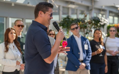 a man holding a microphone and a drink