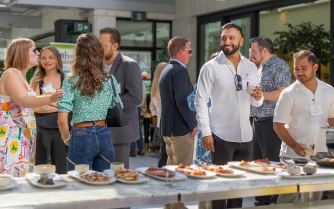 a group of people standing around a table with food on it
