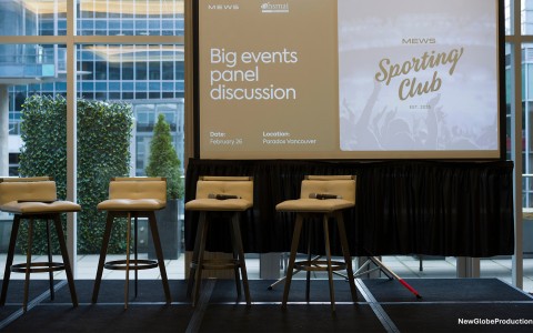 a stage with a large screen and chairs