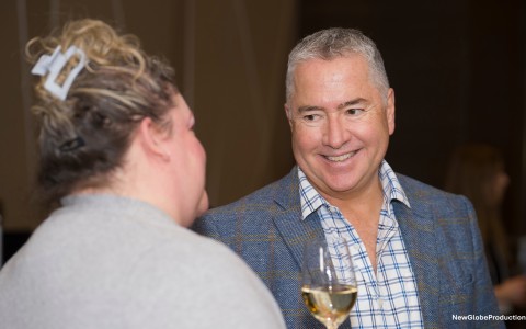 a man and woman talking and drinking wine