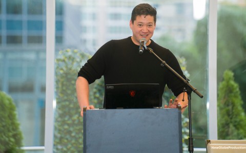 a man standing at a podium with a microphone