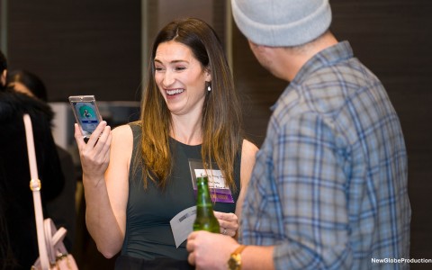 a woman smiling at a man holding a phone
