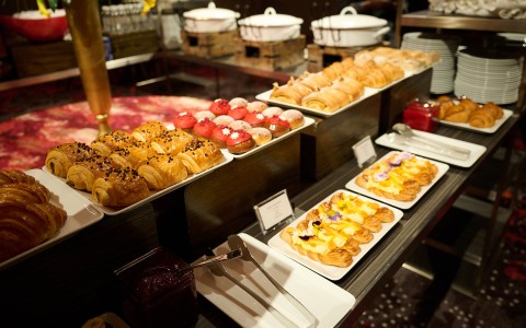 a table with many plates of pastries