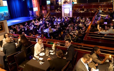 a group of people sitting at tables in a restaurant