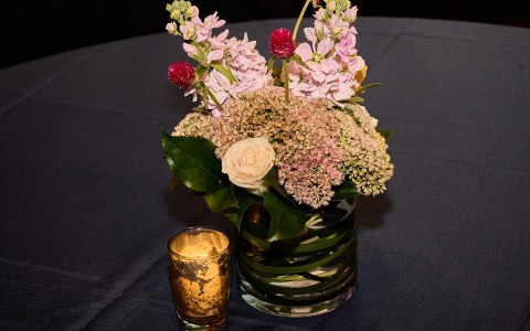a vase of flowers and a candle