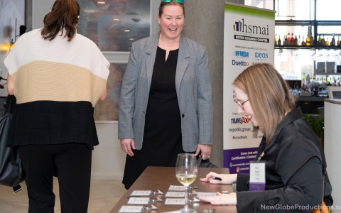 a woman standing next to a table with cards and glasses