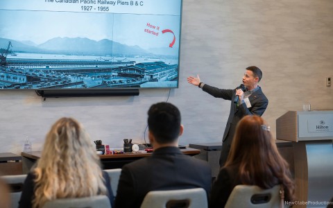 a man in a suit speaking to a group of people in a room