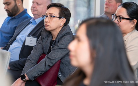 a woman sitting in a room with other people