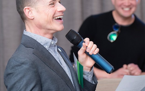a man holding a microphone and smiling