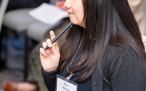 a woman sitting in a chair holding a pen