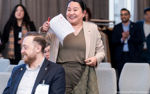 a woman holding a paper and smiling