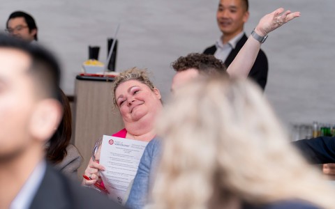 a woman holding a paper and smiling