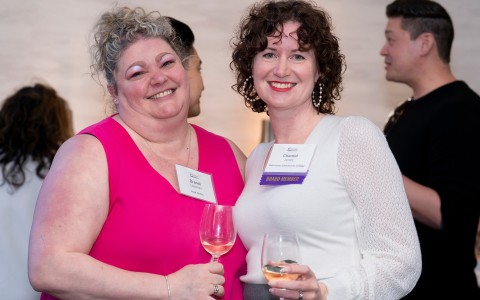 two women holding wine glasses