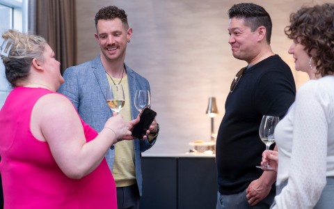 a group of people standing and holding wine glasses