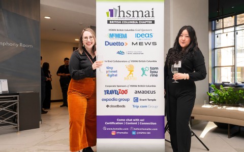 two women standing next to a sign