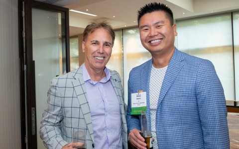 two men standing together smiling
