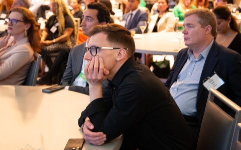 a man sitting at a table with his hand on his face