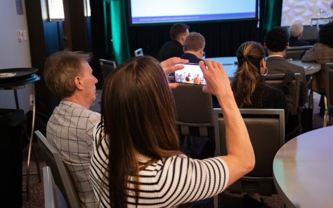a group of people sitting in chairs and holding a cellphone