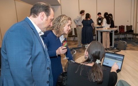 a group of people looking at a laptop