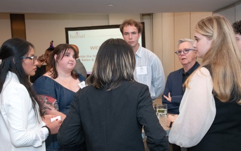 a group of people standing around a table