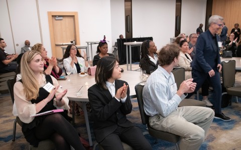 a group of people clapping at a meeting