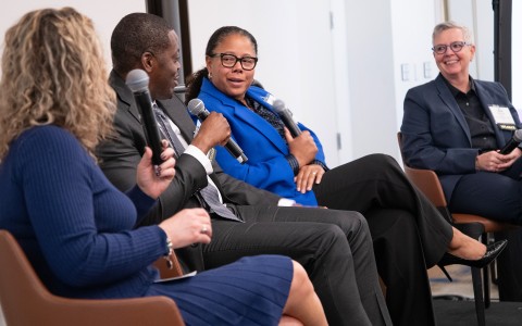 a group of people sitting in chairs talking into microphones