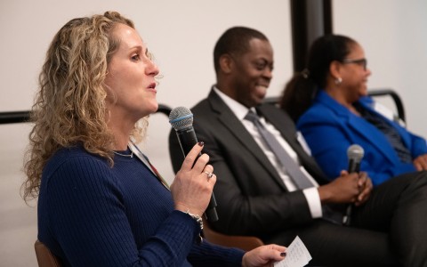 a woman holding a microphone and speaking to a man