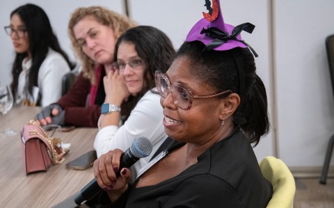 a woman holding a microphone with other women in the background