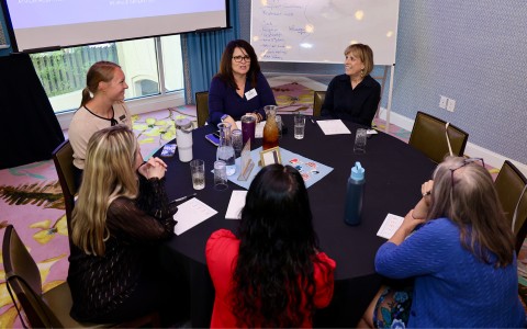 a group of women sitting around a round table