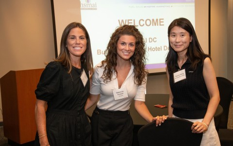 a group of women standing in front of a projector screen