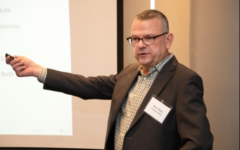 a man in a suit pointing at a screen