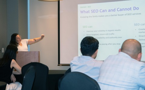 a woman standing at a podium giving a presentation