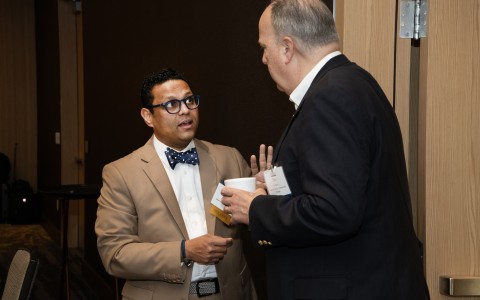 a man in a suit talking to another man