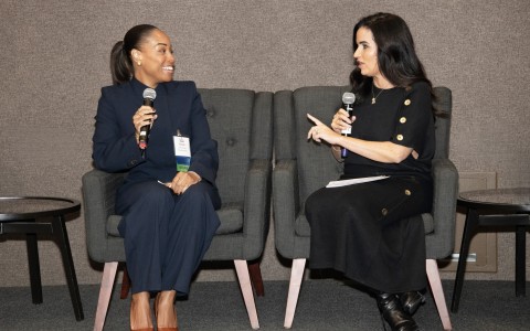 two women sitting in chairs holding microphones