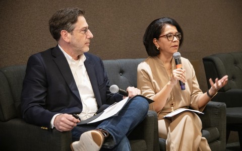 a man and woman sitting in chairs with microphones
