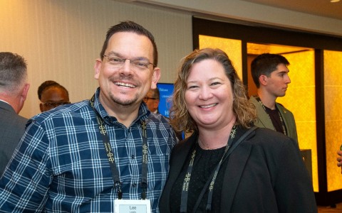 a man and woman smiling at a conference