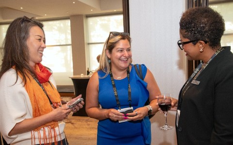 a group of women talking and drinking wine
