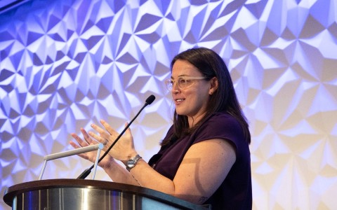 a woman standing at a podium with a microphone