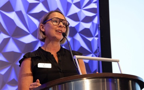 a woman standing at a podium with a microphone