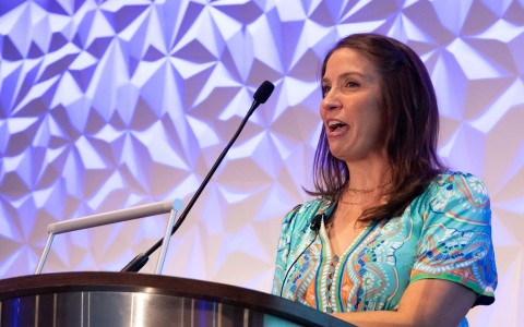 a woman standing at a podium with a microphone
