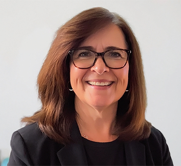 a woman wearing glasses and smiling