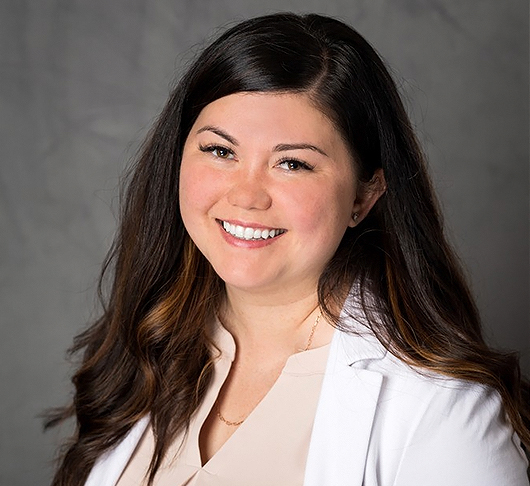 a woman with long brown hair smiling