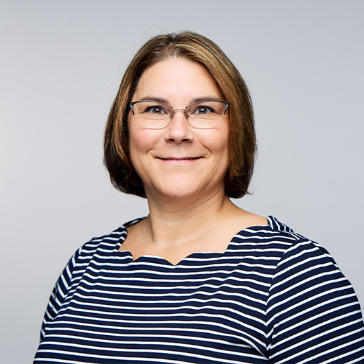 a woman wearing glasses and a striped shirt