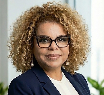 a woman with curly blonde hair wearing glasses