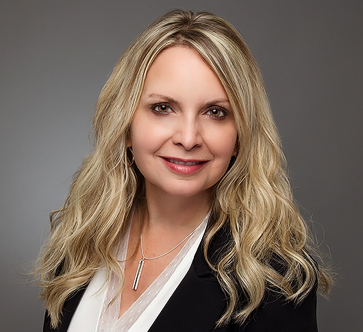 a woman with blonde hair wearing a black jacket and white shirt