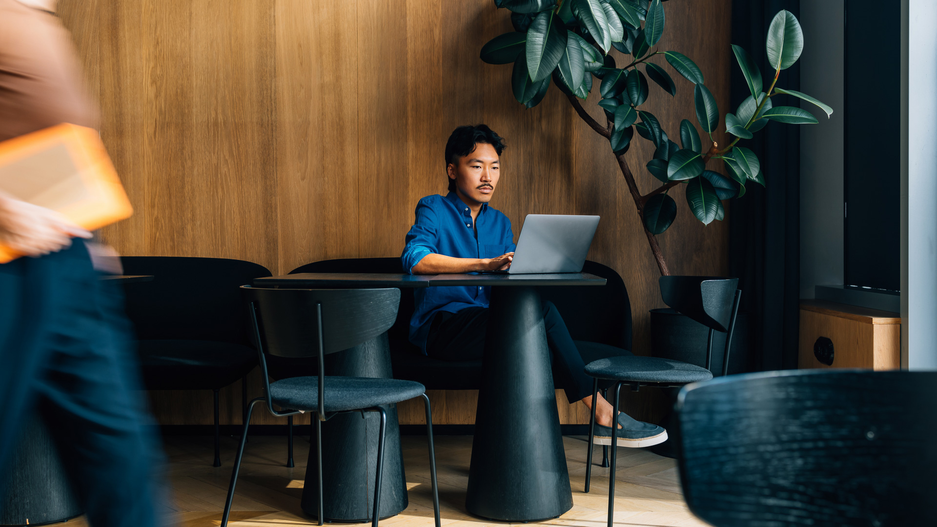 a man sitting at a table with a laptop
