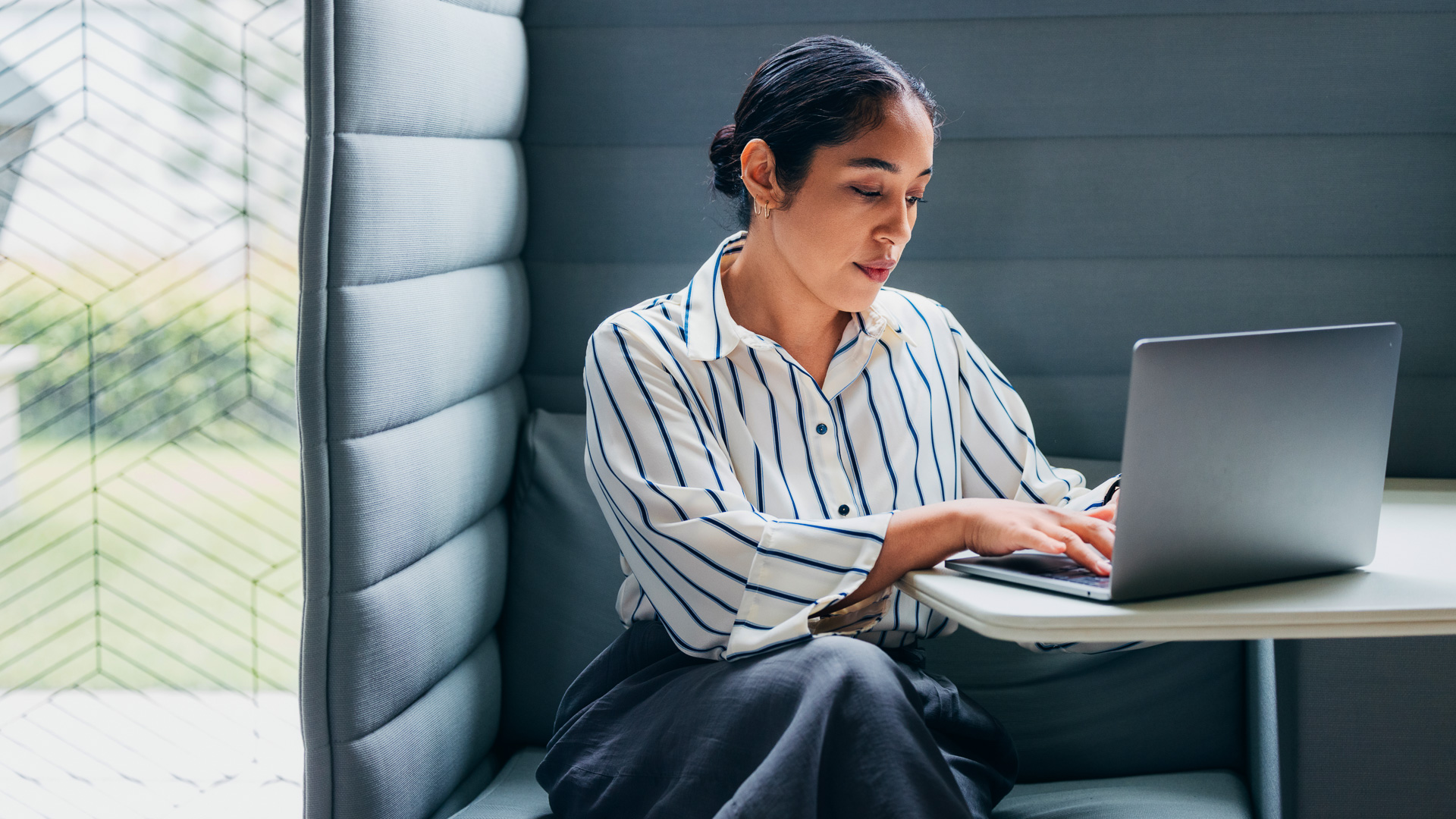 a woman sitting on a couch using a laptop