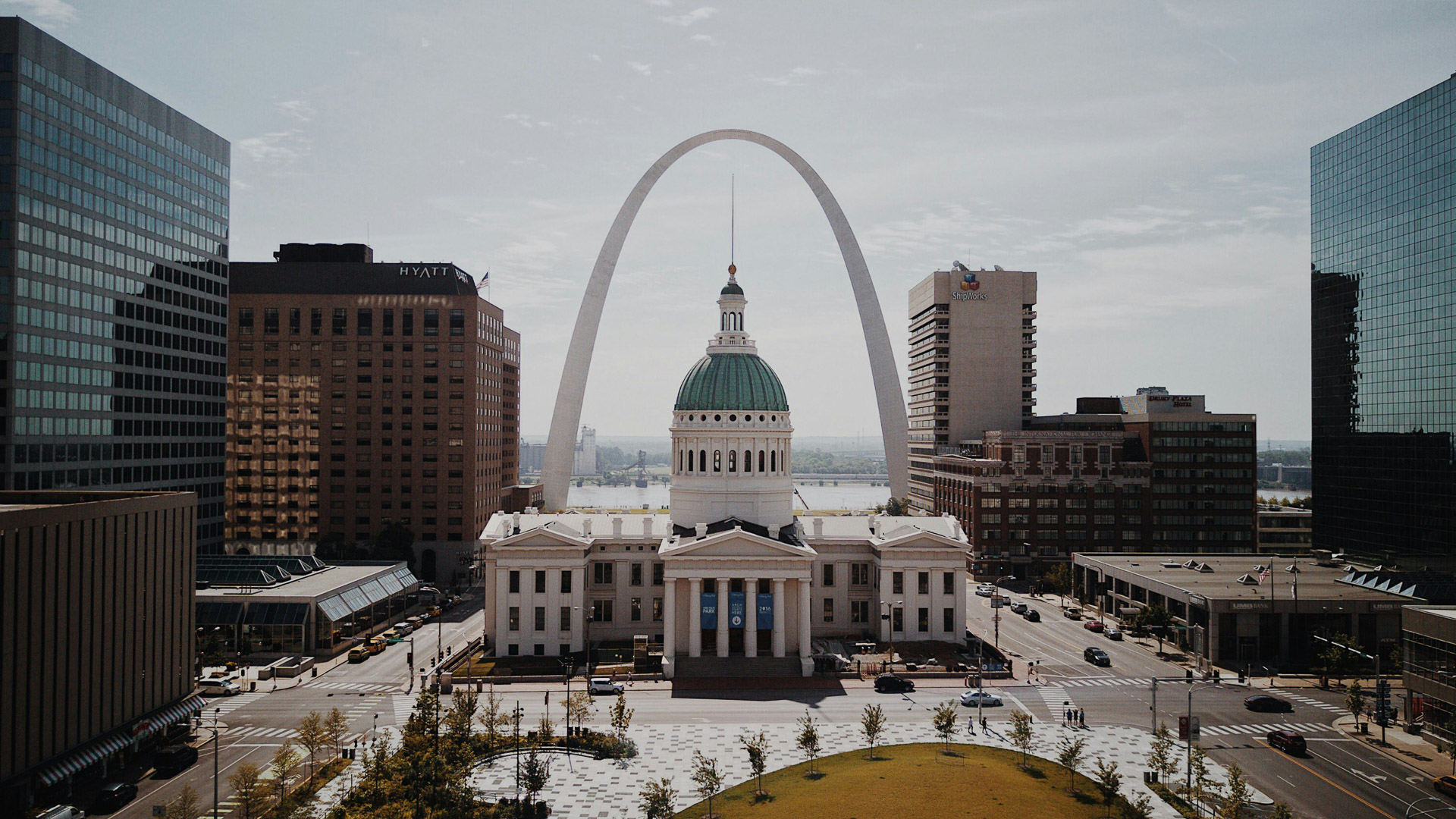 a large white building with a green dome and a large arch