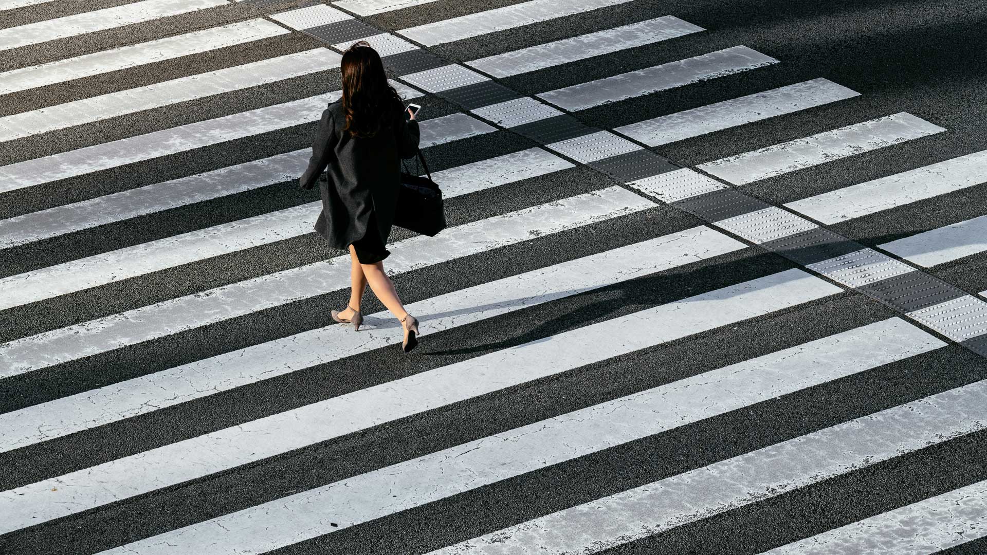 a woman walking across a crosswalk