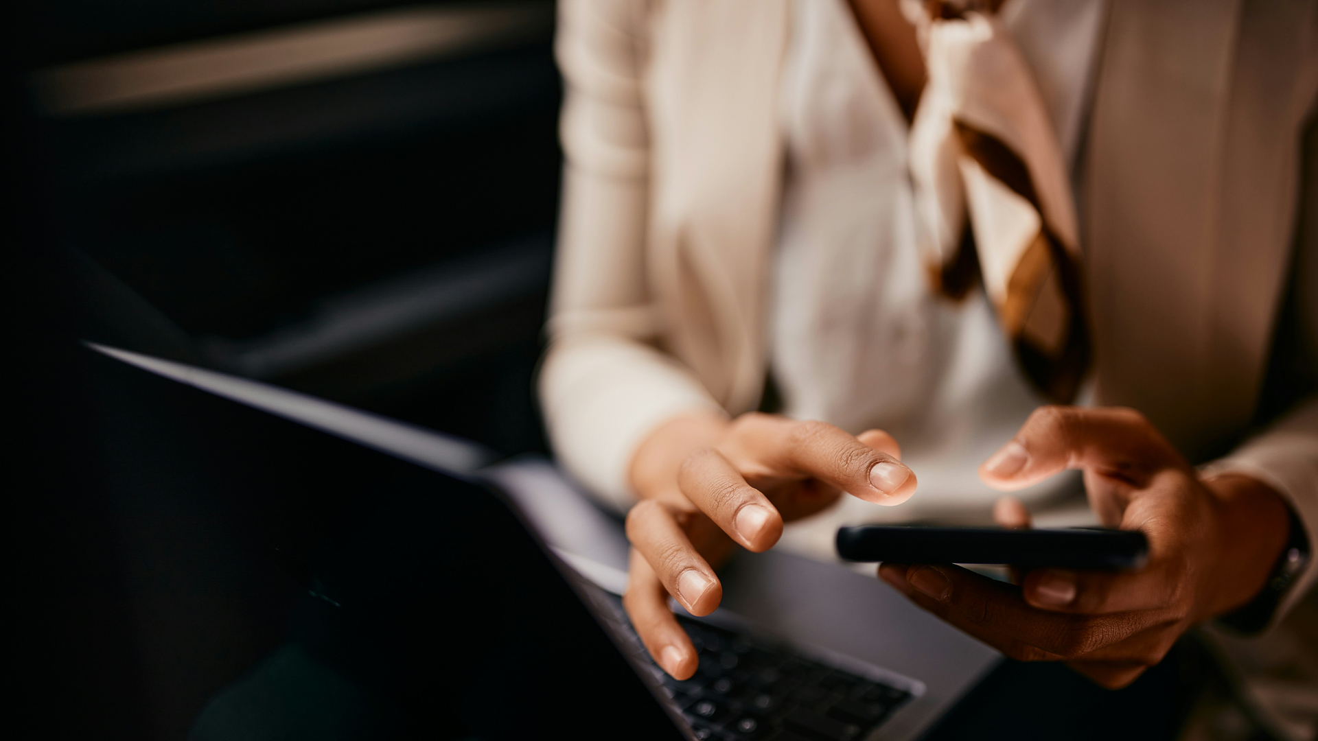 a woman using a phone and laptop